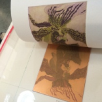 A second layer of violet is printed over the initial green print.